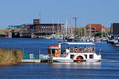 Deutschland, Niedersachsen, Nordseeküste,Ostfriesland, Raddampfer am Harlesiel mit der Schiffsschleuse im Hintegrund